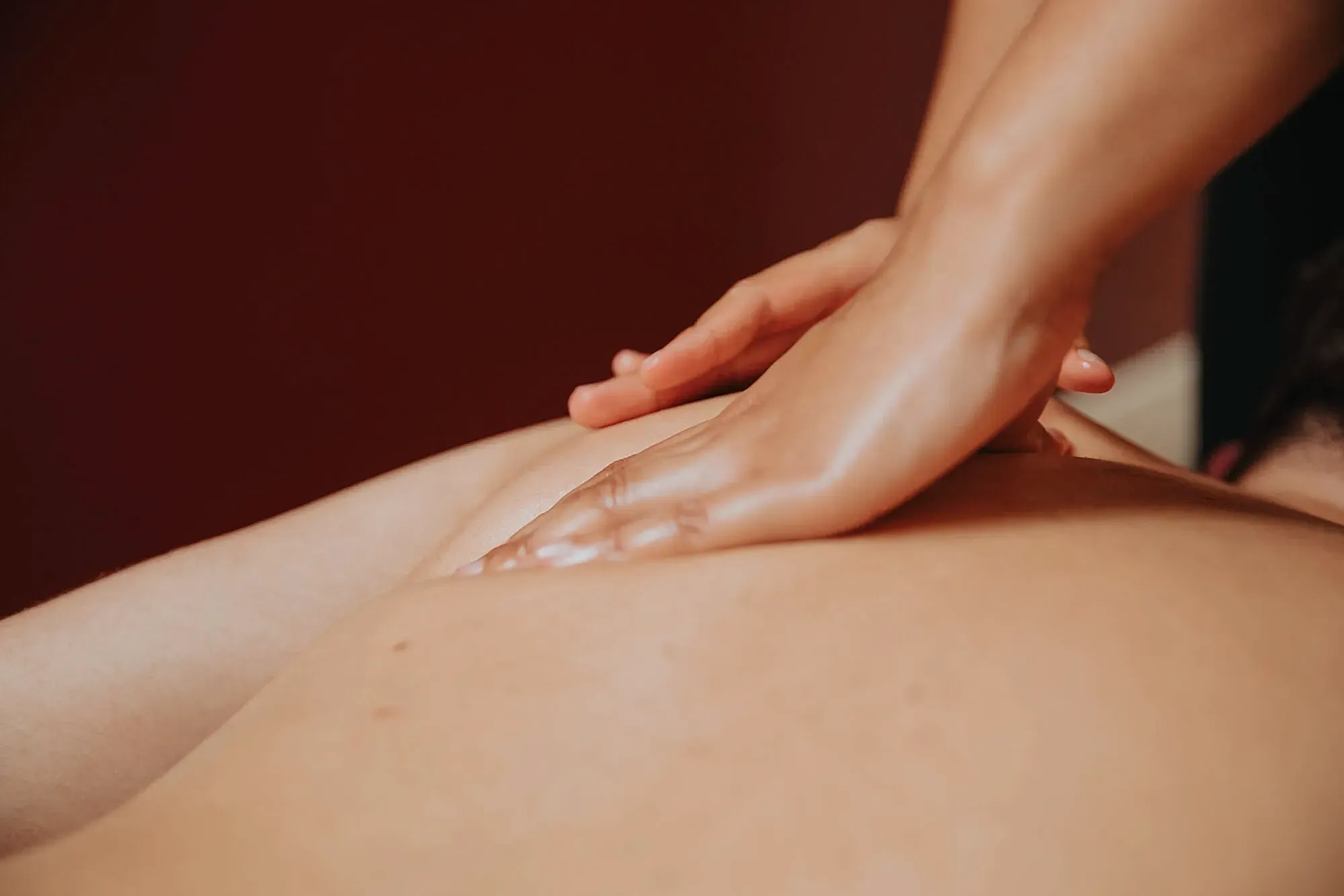 True Wellness Spa Package Closed up of a hand massaging the shoulder back